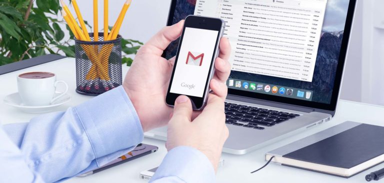 Gmail app on the iPhone display in man hands and Gmail desktop v