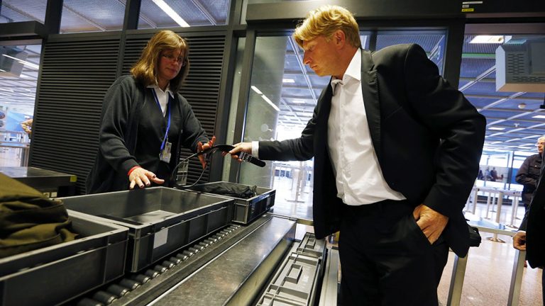 Passenger gives in his belt as he undergoes a security check at Frankfurt Airport
