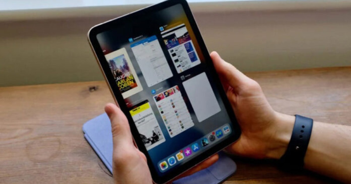 Người dùng cầm iPad Mini hiển thị giao diện đa nhiệm