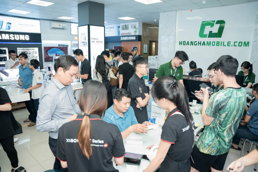 Khách hàng và nhân viên tập trung quanh quầy tại cửa hàng Hoàng Hà Mobile
